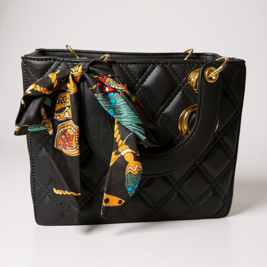 Quilted mini handbag with gold hardware and patterned scarf detail on handle in black faux leather
